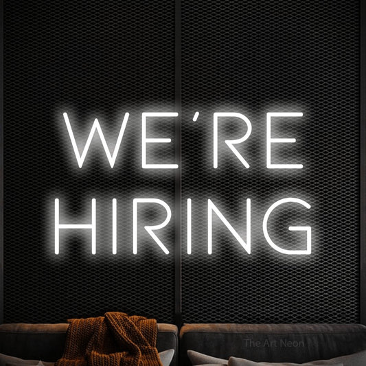 Cool white LED neon sign reading "We're Hiring" against a black textured wall for restaurant décor