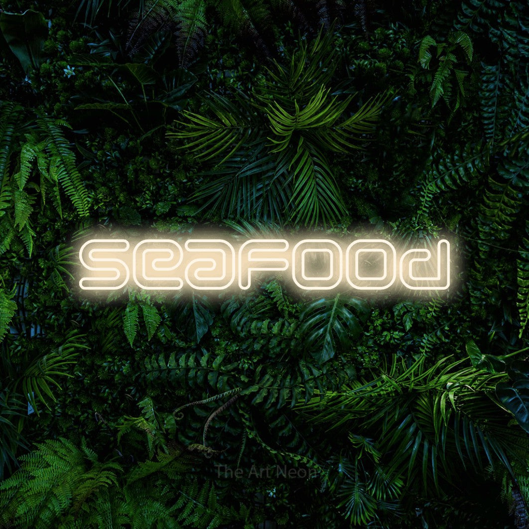 Warm white outline-style LED neon sign reading "Seafood" against a dense tropical foliage wall for restaurant décor