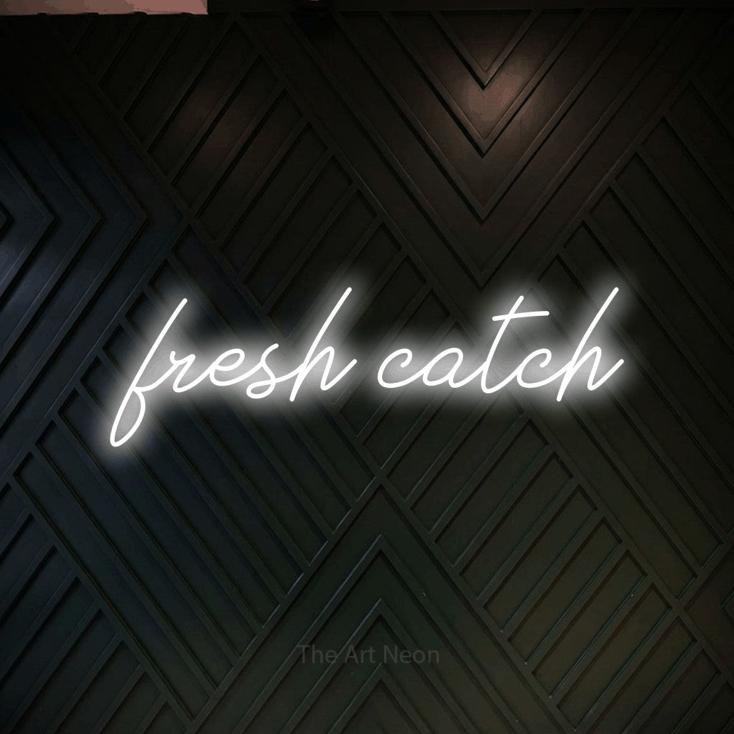 Cool white script-style LED neon sign reading "Fresh Catch" against a dark geometric wood wall for restaurant décor