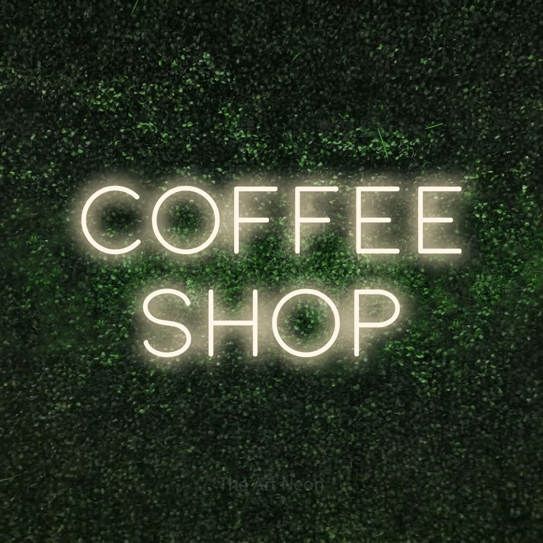 Warm white LED neon sign reading "Coffee Shop" against a textured green moss wall for café décor