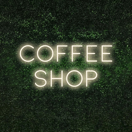 Warm white LED neon sign reading "Coffee Shop" against a textured green moss wall for café décor