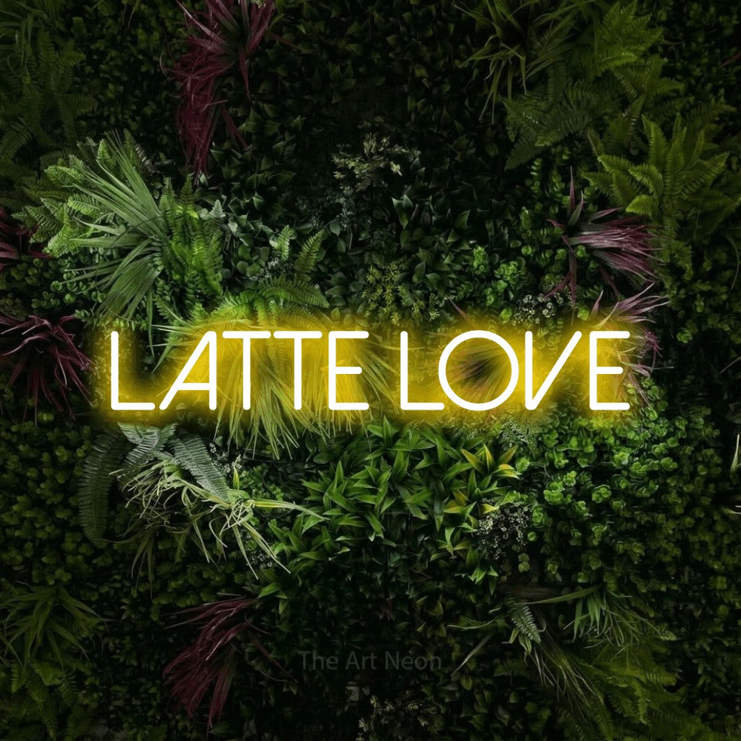 Yellow LED neon sign reading "Latte Love" against a lush garden wall with pink flowers for café décor