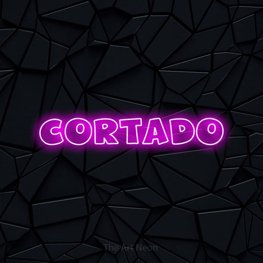 Pink outline-style LED neon sign reading "Cortado" against a black faceted wall for café décor