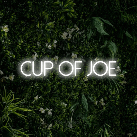 Cool white LED neon sign reading "Cup of Joe" against a leafy green wall for café décor