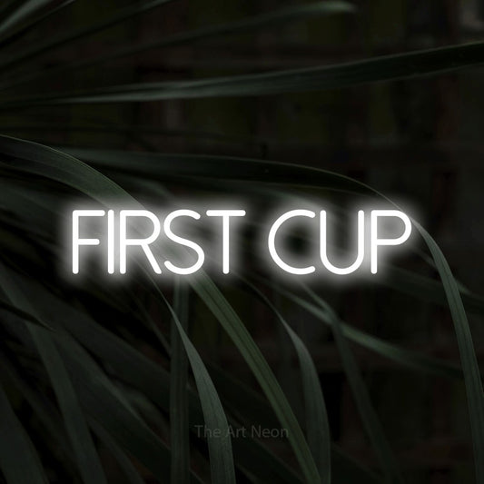 Cool white LED neon sign reading "First Cup" against dark tropical leaves for café décor