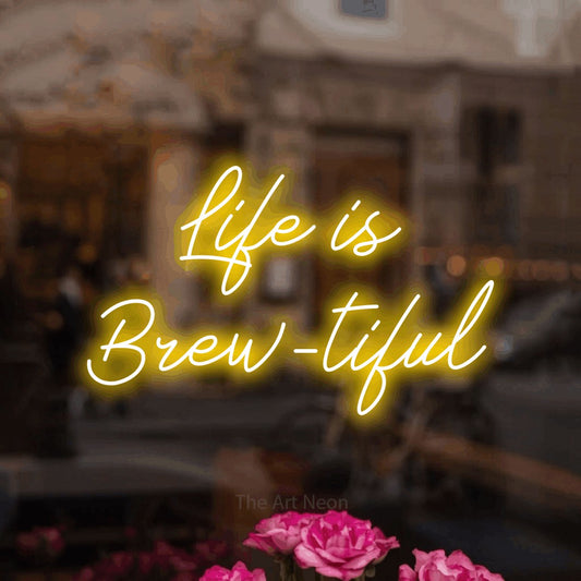 Yellow script-style LED neon sign reading "Life is Brew-tiful" in a softly blurred café interior for café décor