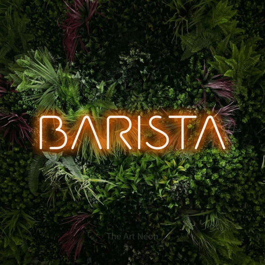 Orange LED neon sign reading "Barista" against a lush garden wall with pink flowers for café décor