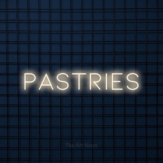 Warm white LED neon sign reading "Pastries" against a dark blue tiled wall for café décor
