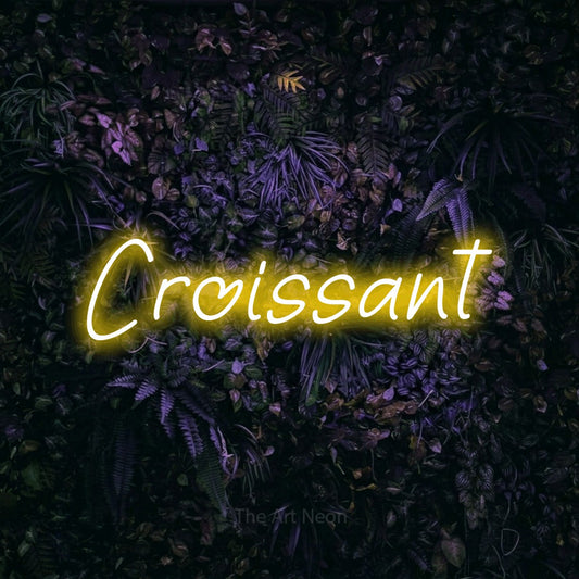 Yellow LED neon sign reading "Croissant" against a purple floral wall for café décor