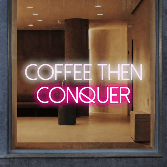 Hot pink and cool white LED neon sign reading "Coffee Then Conquer" in a warm modern interior for café décor