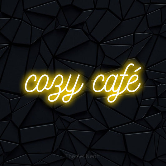 Yellow script-style LED neon sign reading "Cozy Café" against a black faceted wall for café décor