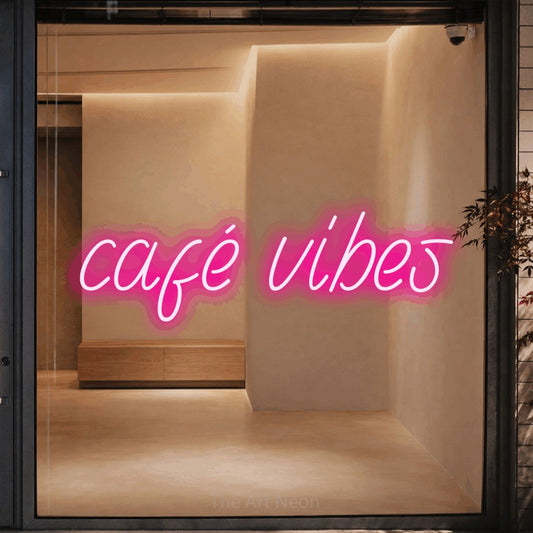 Hot pink LED neon sign reading "Café Vibes" against a warm beige alcove wall for café décor