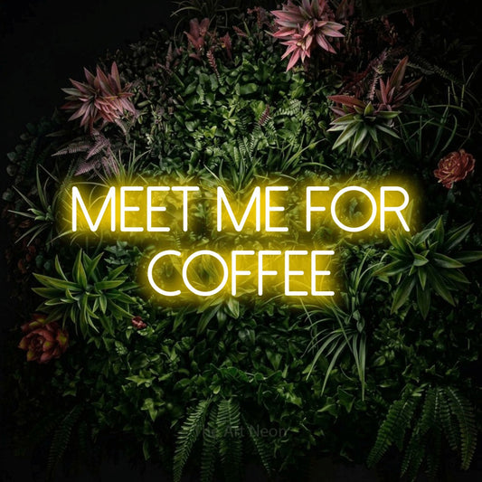 Yellow LED neon sign reading "Meet Me for Coffee" against a flowering garden wall for café décor