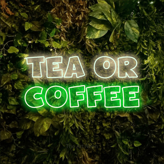 Green and warm white outline-style LED neon sign reading "Tea or Coffee" against a textured moss and foliage wall
