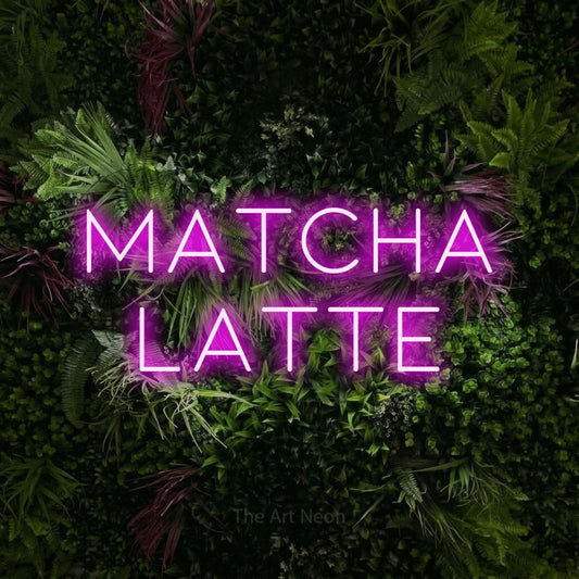 Pink LED neon sign reading "Matcha Latte" against a lush garden wall with pink flowers for café décor
