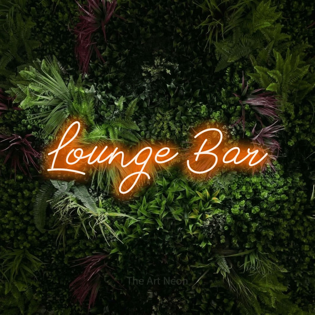 Orange script-style LED neon sign reading "Lounge Bar" against a lush garden wall with pink flowers for bar décor