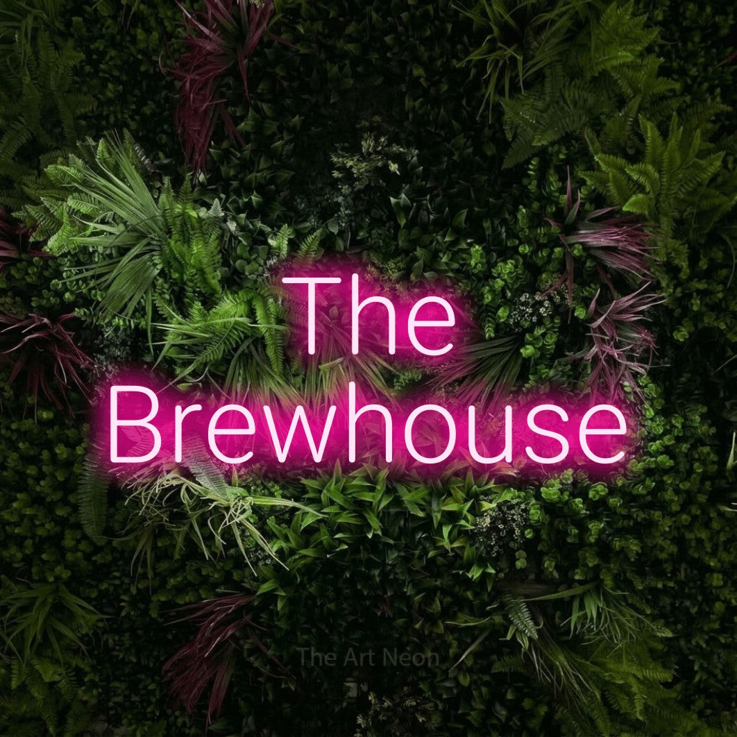 Hot pink LED neon sign reading "The Brewhouse" against a lush garden wall with pink flowers for bar décor