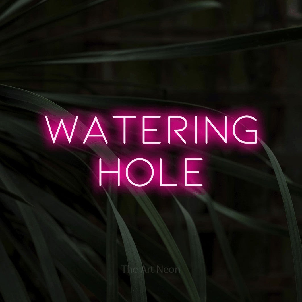 Hot pink LED neon sign reading "Watering Hole" against dark tropical leaves for bar décor