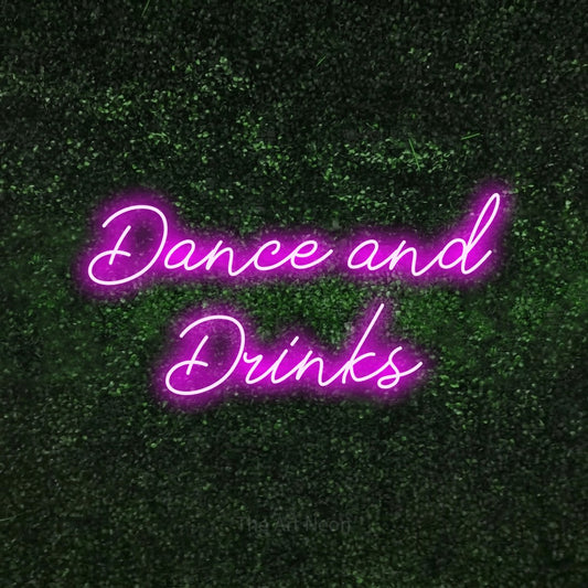 Enseigne néon à DEL à lumière rose, de style manuscrit, affichant « Dance and Drinks » sur un mur texturé de mousse verte, pour décorer un bar