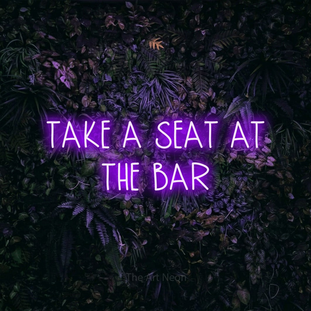 Purple LED neon sign reading "Take a Seat at the Bar" against a purple floral wall for bar décor