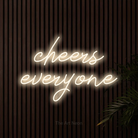 Warm white script-style LED neon sign reading "Cheers Everyone" against dark wooden slats for bar décor