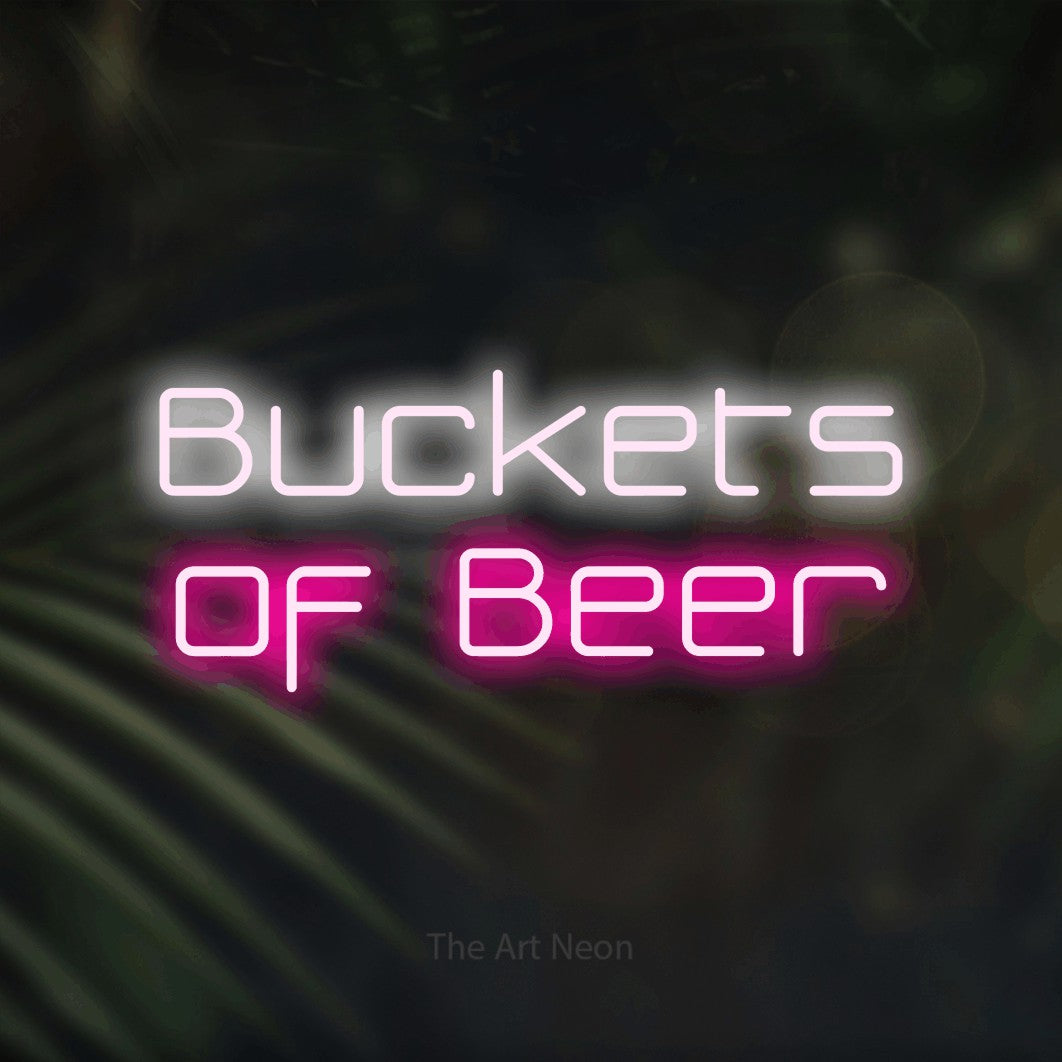 Hot pink and cool white LED neon sign reading "Buckets of Beer" against dark blurred palm leaves for bar décor
