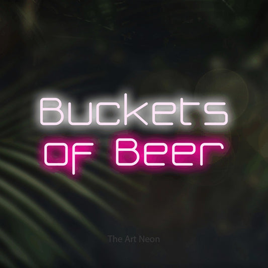 Hot pink and cool white LED neon sign reading "Buckets of Beer" against dark blurred palm leaves for bar décor