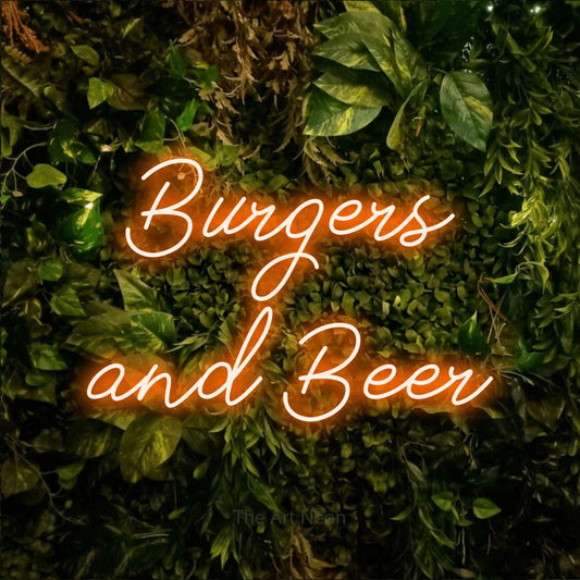 Orange script-style LED neon sign reading "Burgers and Beer" against a textured moss and foliage wall for bar décor
