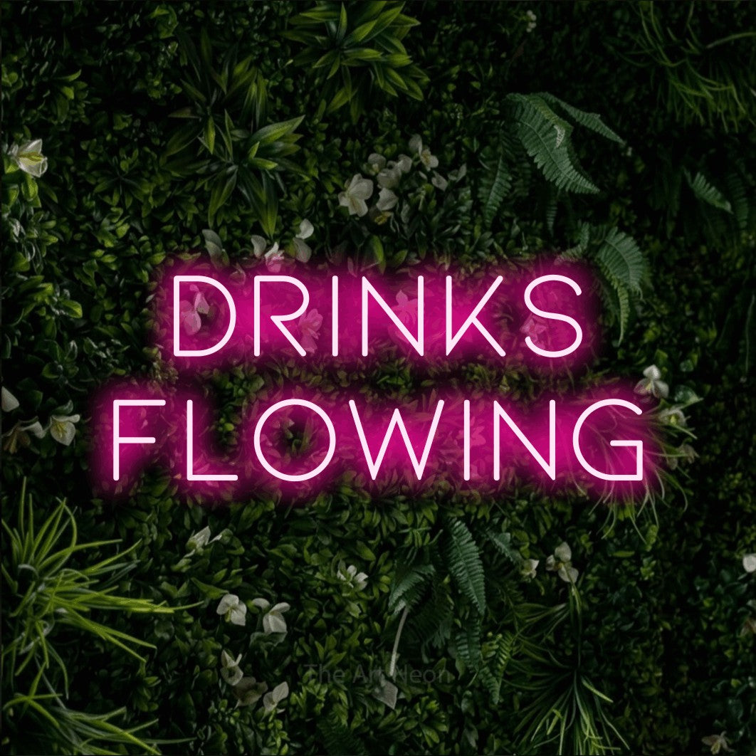 Hot pink LED neon sign reading "Drinks Flowing" against a leafy green wall for bar décor