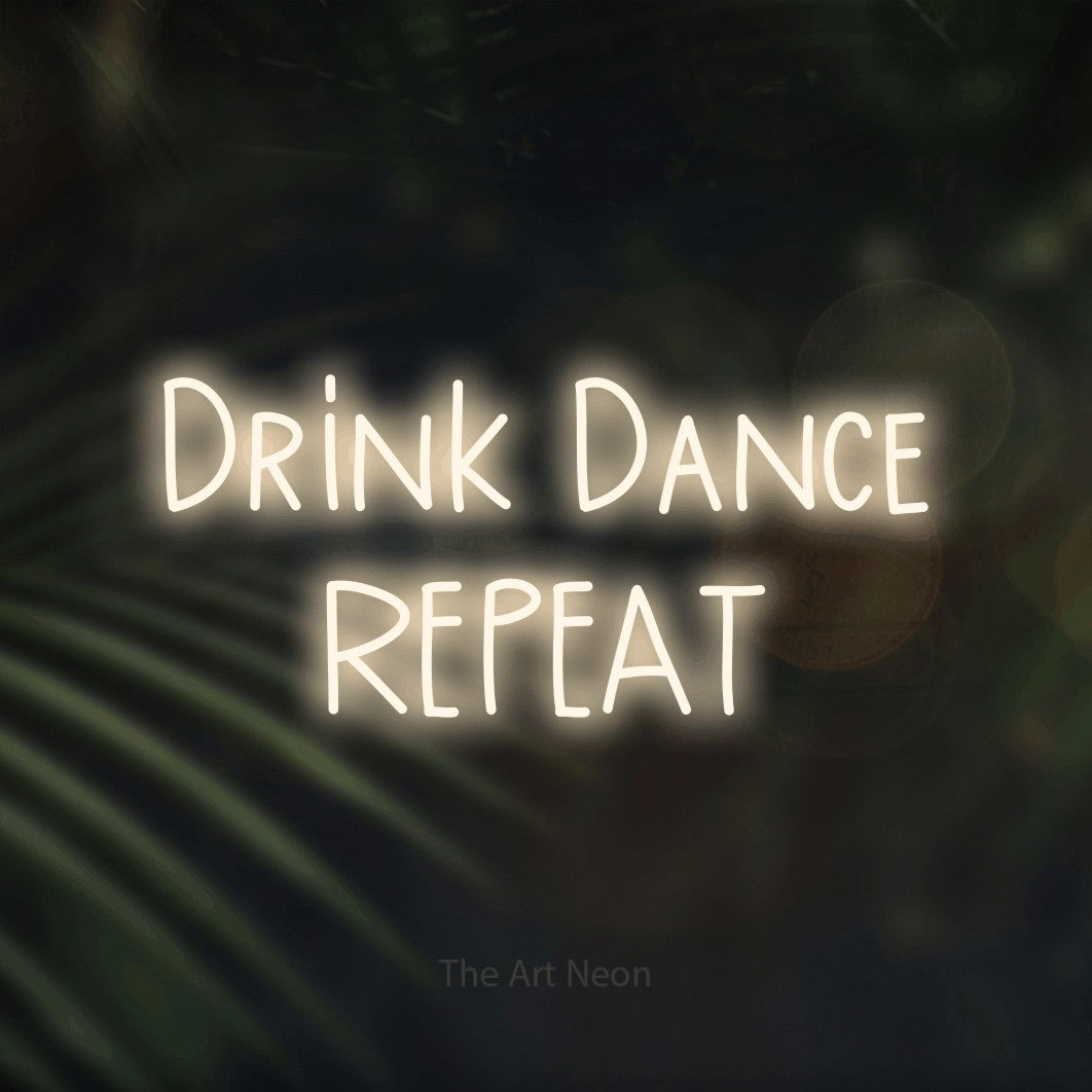 Warm white LED neon sign reading "Drink Dance Repeat" against dark blurred palm leaves for bar décor