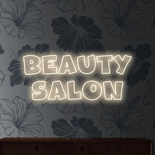 Warm white outline-style LED neon sign reading "Beauty Salon" against grey floral wallpaper for salon décor