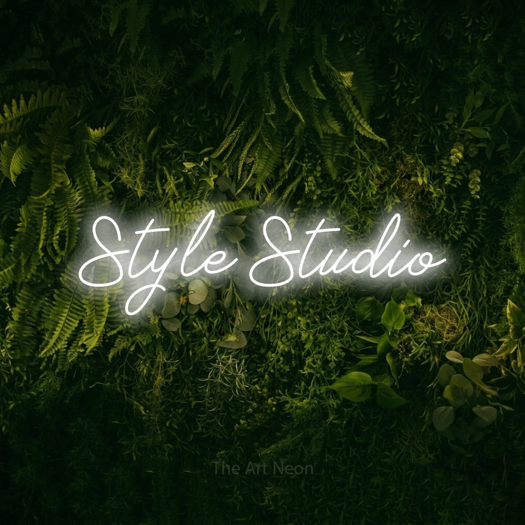 Cool white script-style LED neon sign reading "Style Studio" against a moss-covered green wall for salon décor