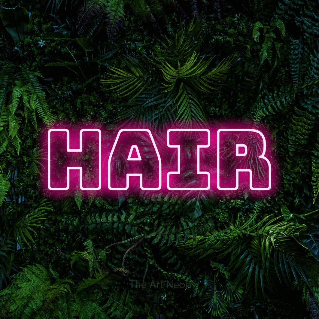 Hot pink outline-style LED neon sign reading "Hair" against a dense tropical foliage wall for salon décor