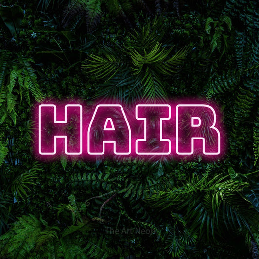 Hot pink outline-style LED neon sign reading "Hair" against a dense tropical foliage wall for salon décor
