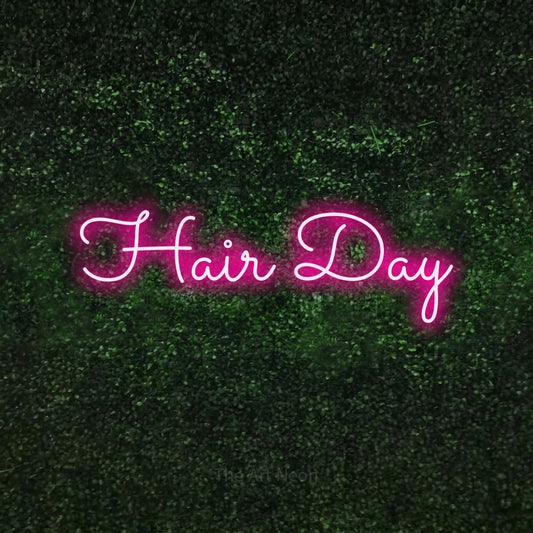 Hot pink LED neon sign reading "Hair Day" against a textured green moss wall for salon décor