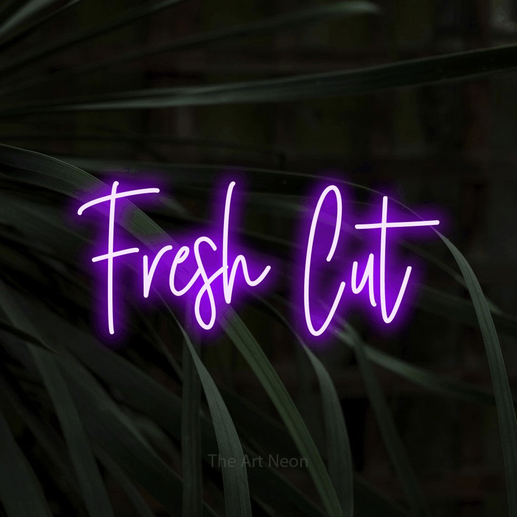 Purple script-style LED neon sign reading "Fresh Cut" against dark tropical leaves for salon décor