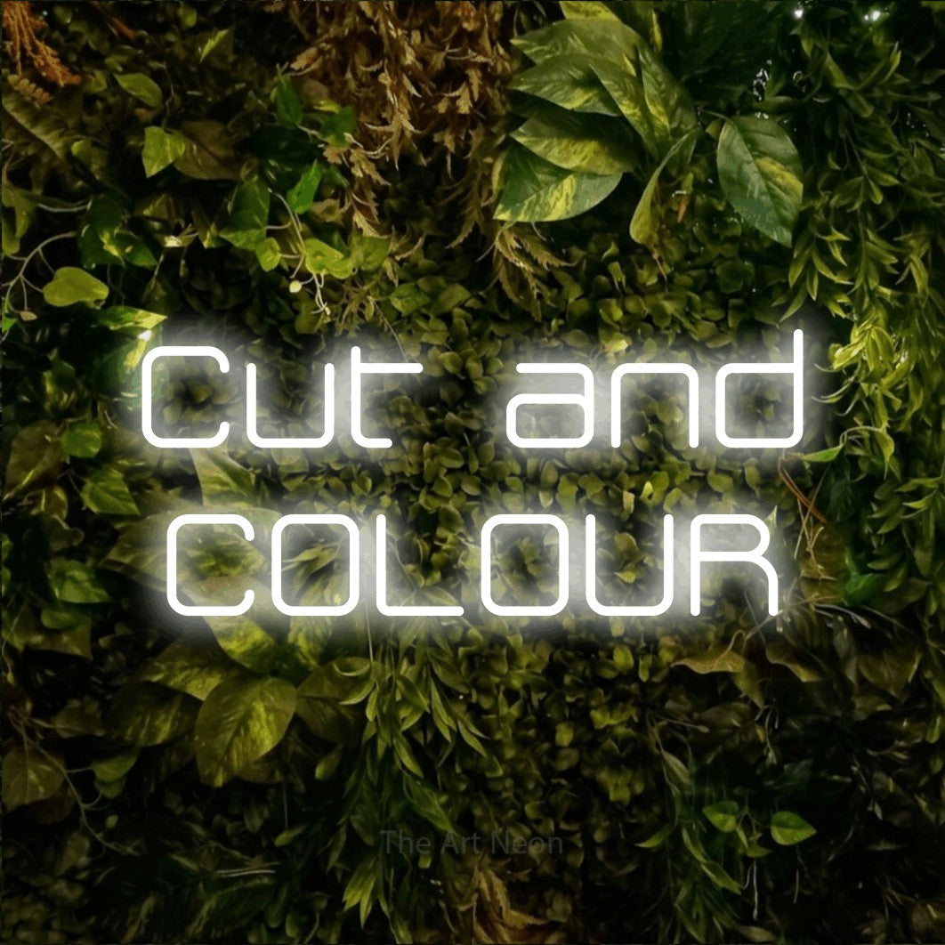 Cool white LED neon sign reading "Cut and Colour" against a textured moss and foliage wall for salon décor