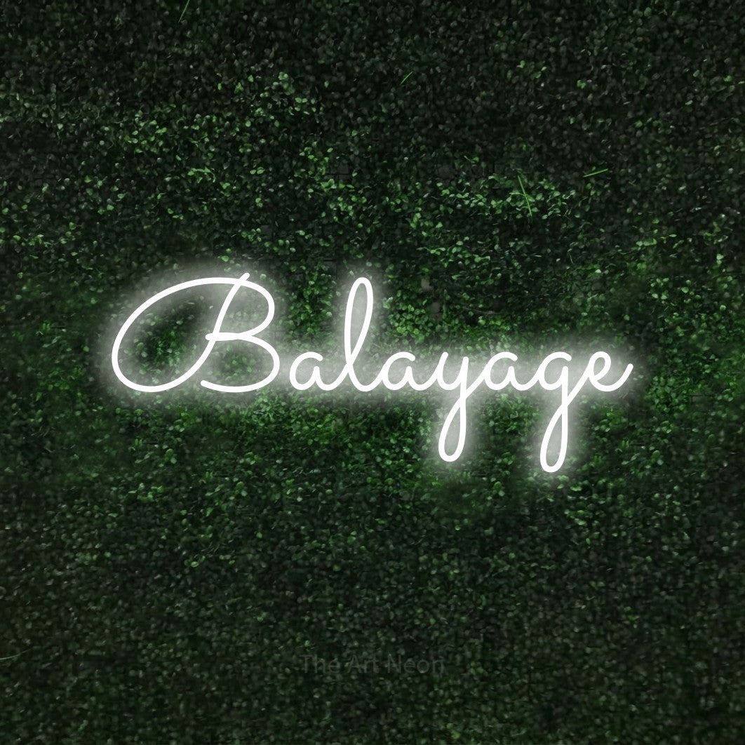 Cool white LED neon sign reading "Balayage" against a textured green moss wall for salon décor