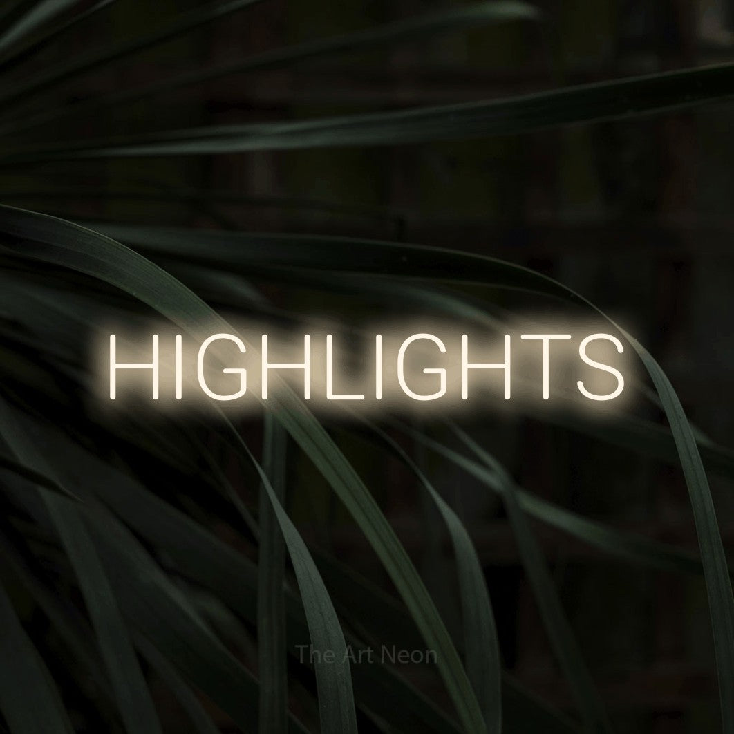 Warm white LED neon sign reading "Highlights" against dark tropical leaves for salon décor