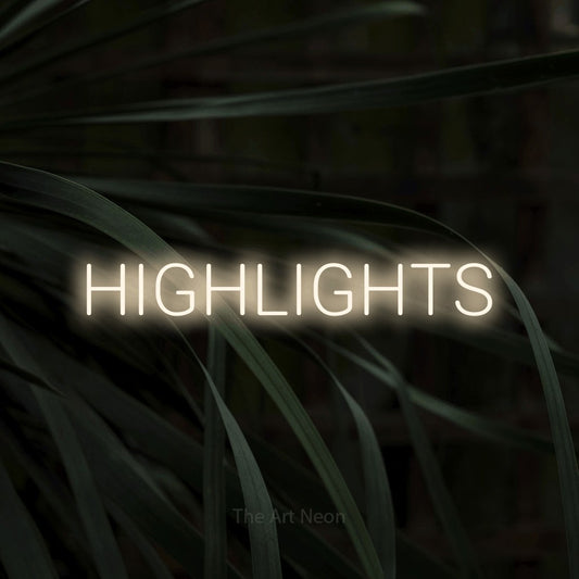Warm white LED neon sign reading "Highlights" against dark tropical leaves for salon décor
