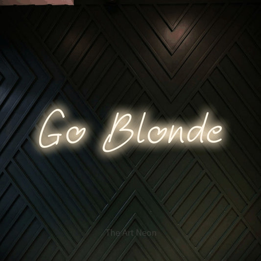 Warm white LED neon sign reading "Go Blonde" against a dark geometric wood wall for salon décor