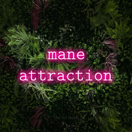 Hot pink LED neon sign reading "Mane Attraction" against a lush garden wall with pink flowers for salon décor