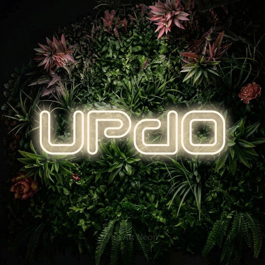 Warm white outline-style LED neon sign reading "Updo" against a flowering garden wall for salon décor
