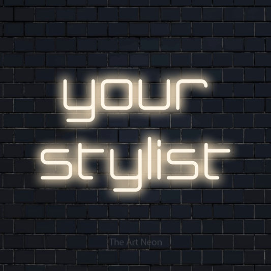 Warm white LED neon sign reading "Your Stylist" against a dark navy brick wall for salon décor