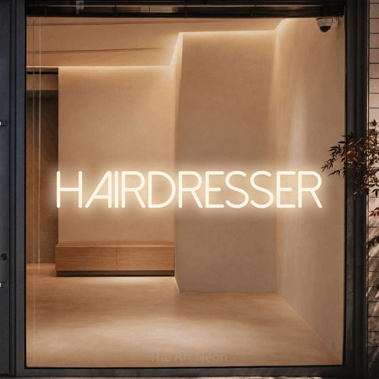 Warm white LED neon sign reading "Hairdresser" against a warm beige alcove wall for salon décor