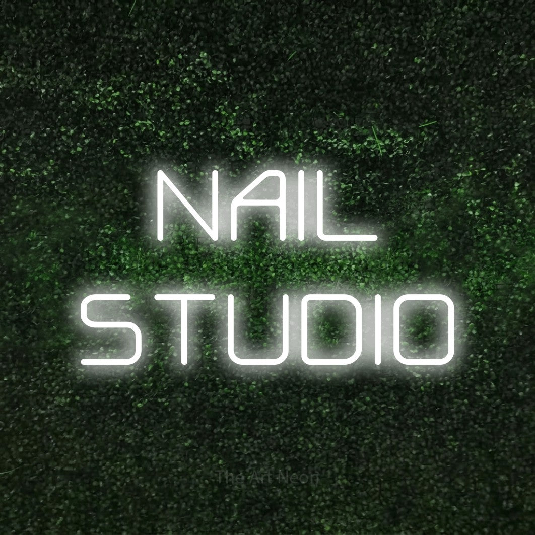 Cool white LED neon sign reading "Nail Studio" against a textured green moss wall for salon décor