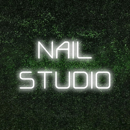 Cool white LED neon sign reading "Nail Studio" against a textured green moss wall for salon décor