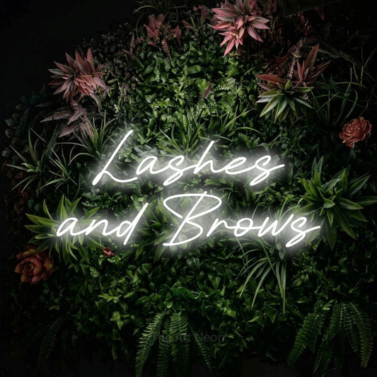 Cool white LED neon sign reading "Lashes and Brows" against a flowering garden wall for salon décor