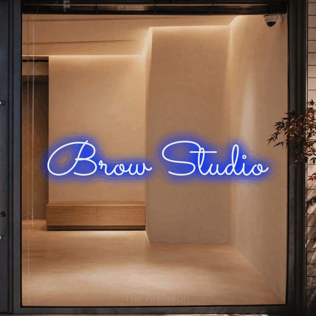 Blue LED neon sign reading "Brow Studio" against a warm beige alcove wall for salon décor