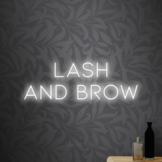 Cool white LED neon sign reading "Lash and Brow" against light grey floral wallpaper for salon décor